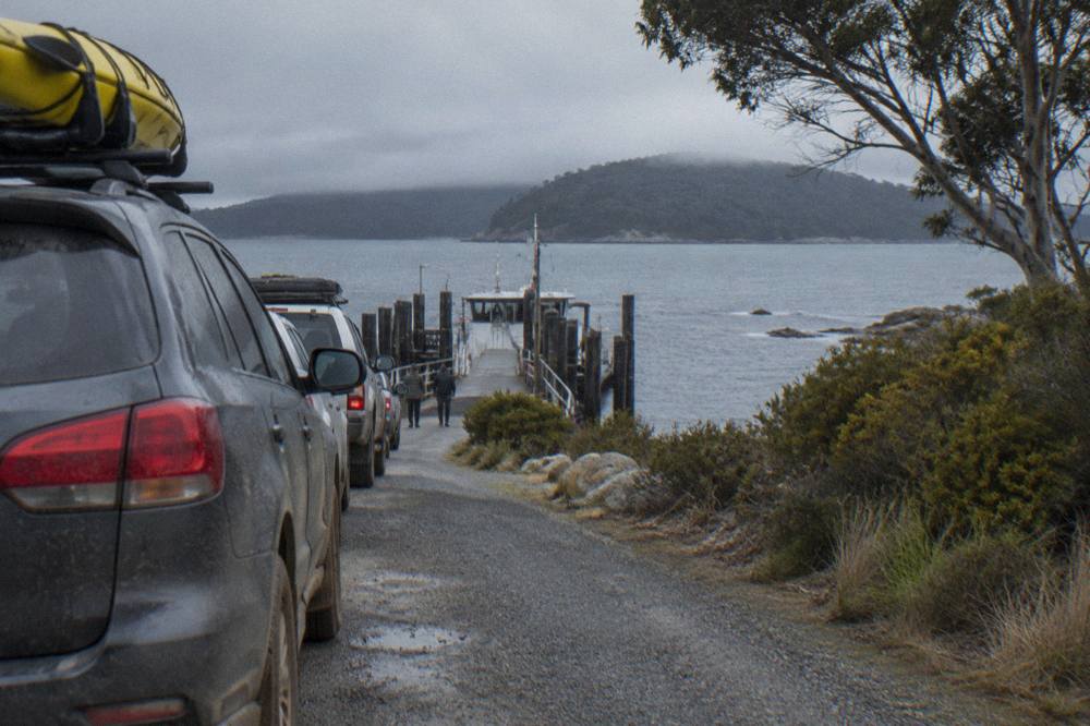 Cars queued on a ramp waiting to board a vehicle ferry at a small port terminal