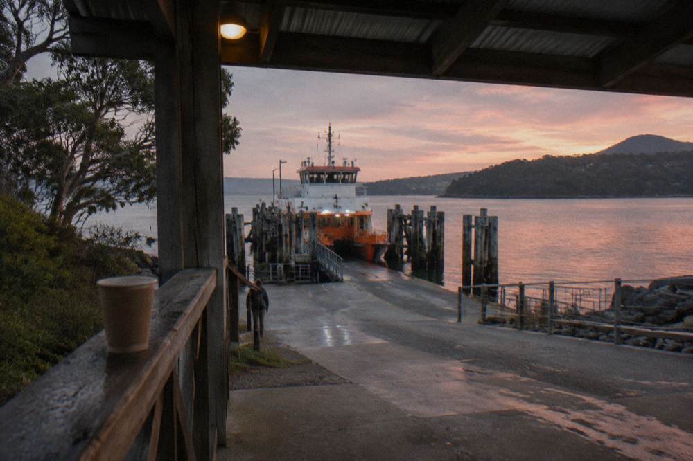 A sheltered harbour terminal with a ramp and moored ferry at dusk