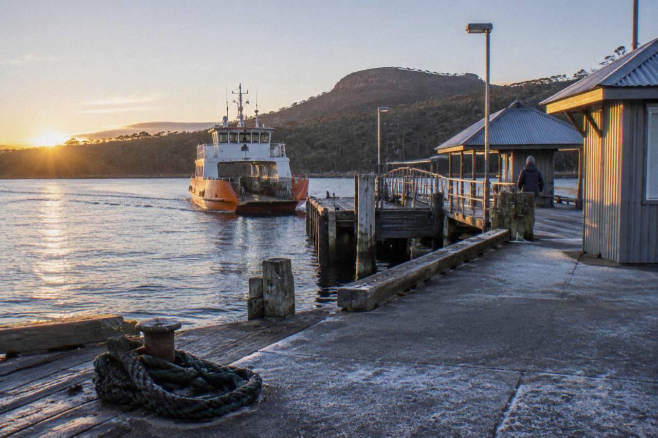 A vehicle ferry loading at a small terminal on a sheltered waterway near Bruny Island