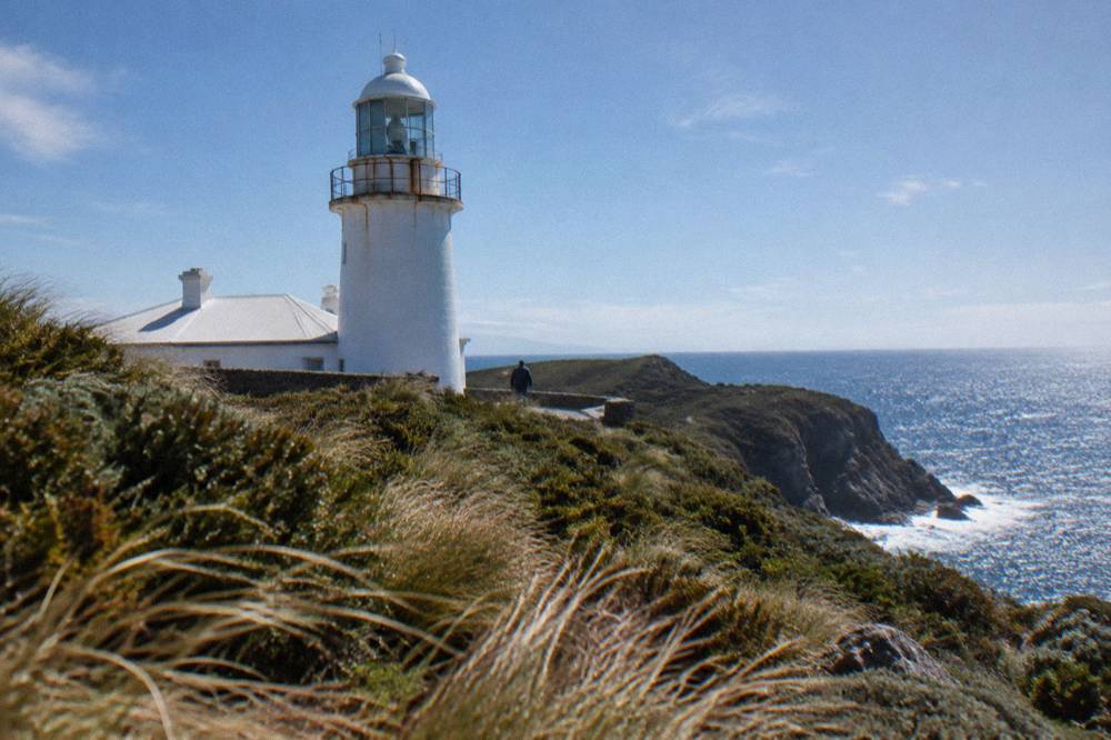 Cape Bruny Lighthouse standing on a grassy headland above the sea