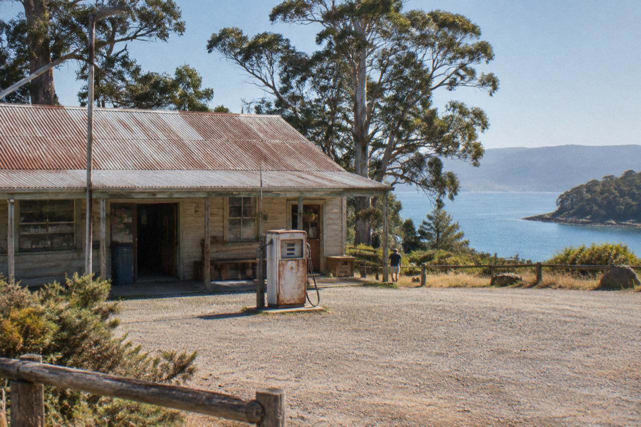 A wooden general store with a fuel pump outside, set against a backdrop of eucalyptus trees on Bruny Island