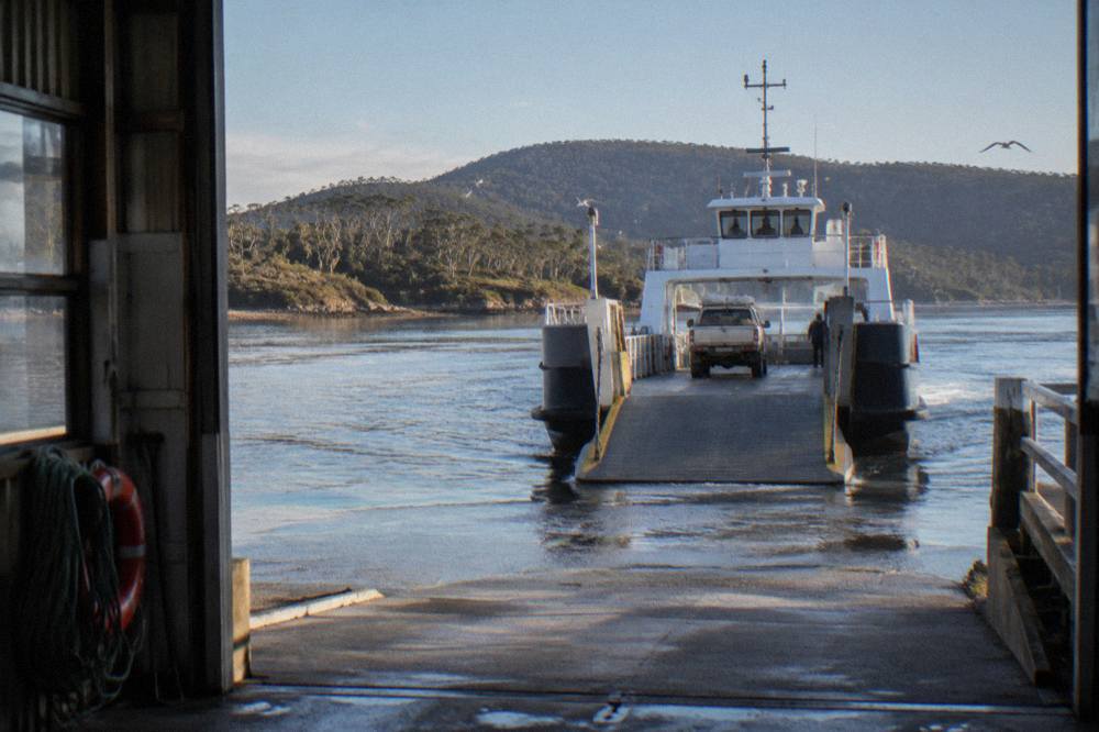 Vehicle ferry approaching the Kettering terminal ramp across calm water