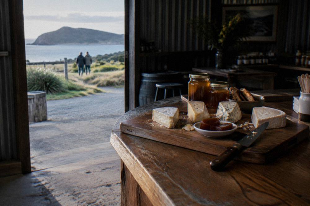 A wooden board of local cheese and condiments on a cellar door counter