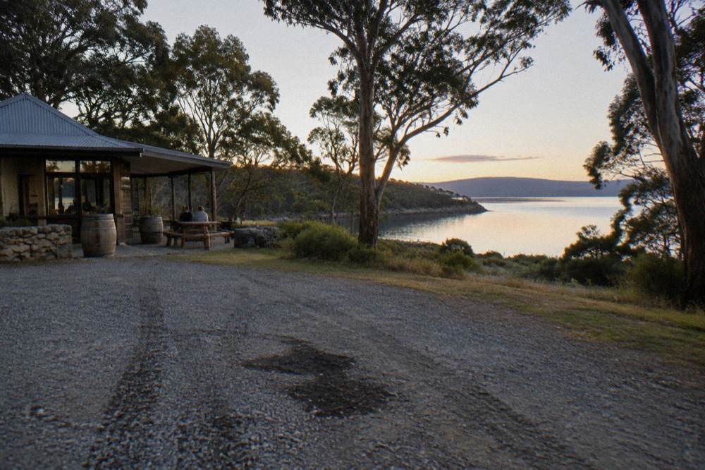 A sheltered bay with calm water and a gravel airstrip clearing among trees