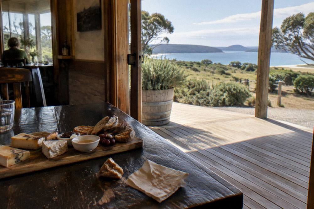 Wooden tasting platter with cheese, honey and bread on a table inside a cellar door