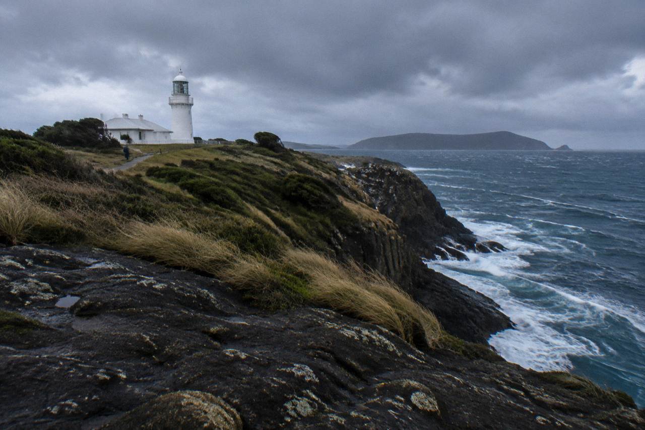 Windy coastline at Cape Bruny with low clouds over dolerite cliffs and ocean swell